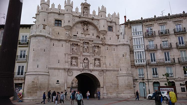 A large squat castellated archway with ornate carvings and crenellations in Burgos