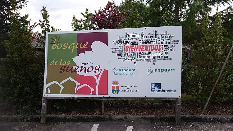 A large welcome sign in many languages at the entrance to the lodge site