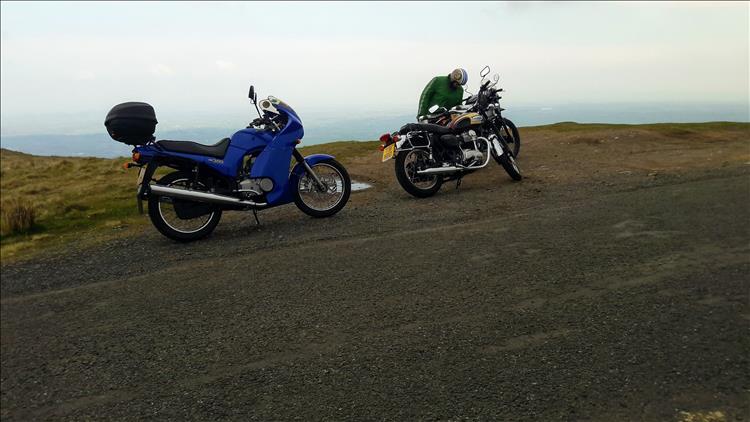 2 motorcycles atop of the hill, but all we can really see is mist in the distance