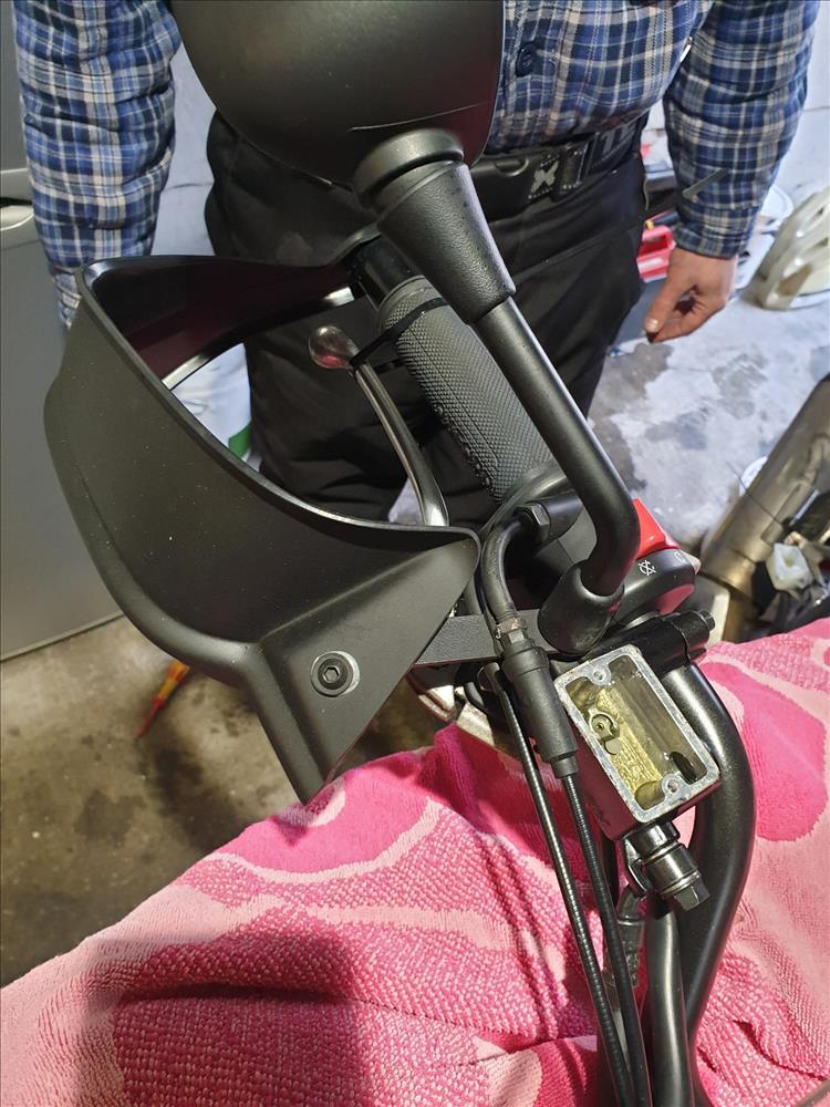 The front brake lever is zip-tied on and the master cylinder is open