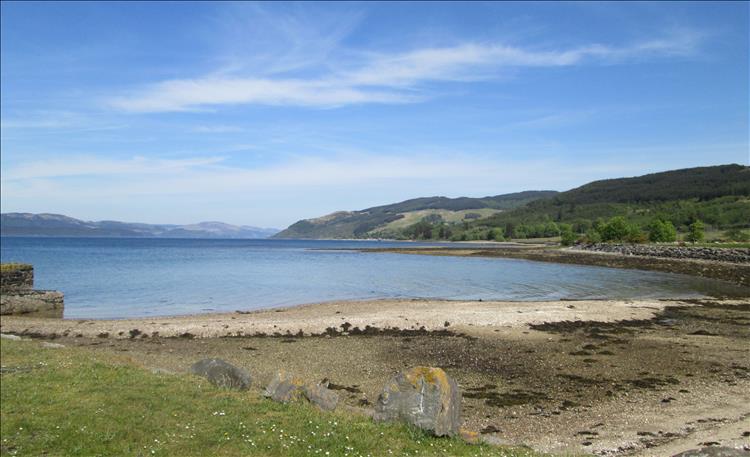 A sandy and stony beach, a very calm Loch Fyne and endless hills in the distance