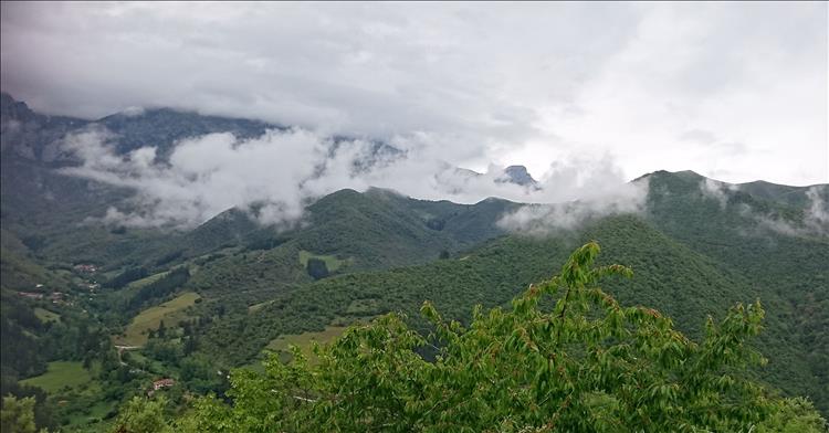 Lush green mountains amidst mist and clouds in Northern Spain
