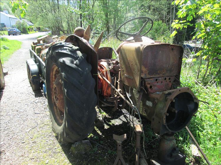 The rusting remains of a tractor, missing everything forward of the steering wheel