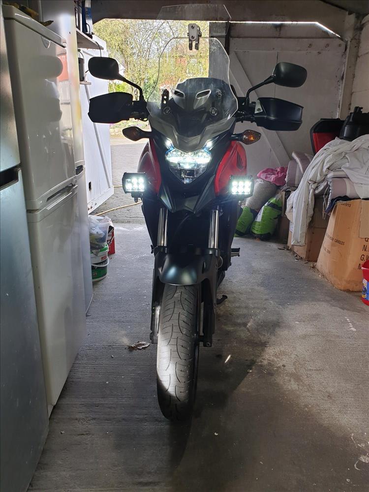 The bike in the garage with the fog lights lit
