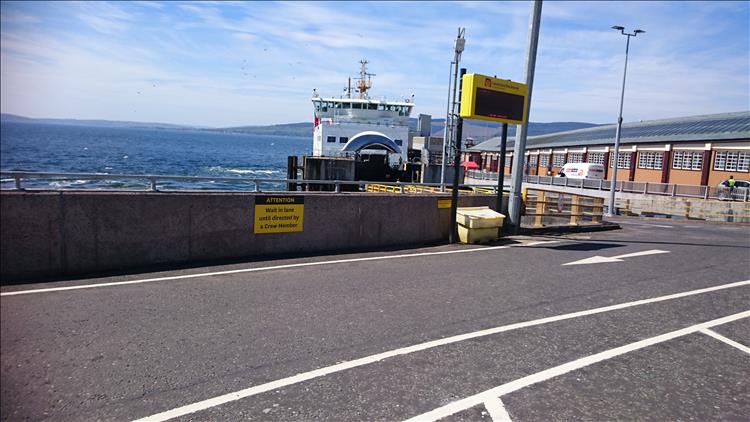 The ferry is in dock and the front bow doors are open as traffic rolls off