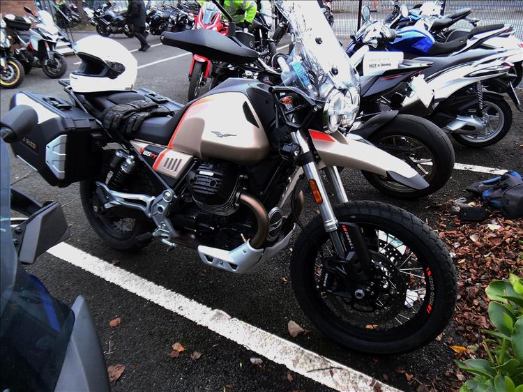 The large v-twin Moto Guzzi adventure bike in the car park ready to ride