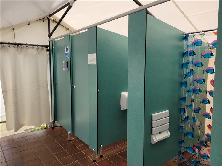 Small shower cubicles, a tiled floor and all in a draughty windswept marquee