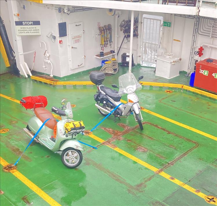 The Innova and the Piaggio strapped to the deck in the rain