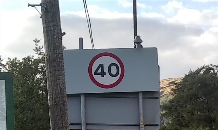 A large 40mph speed limit sign along with the posts and skies behind