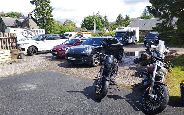 3 motorcycles among the cars and camper vans at The Apiary Cafe Dalwhinnie