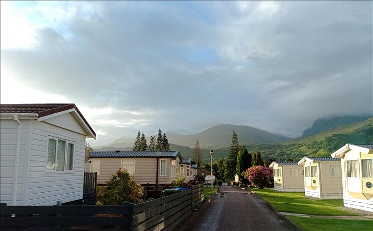 Between the static caravans we see Ben Nevis in the mist and covered in snow