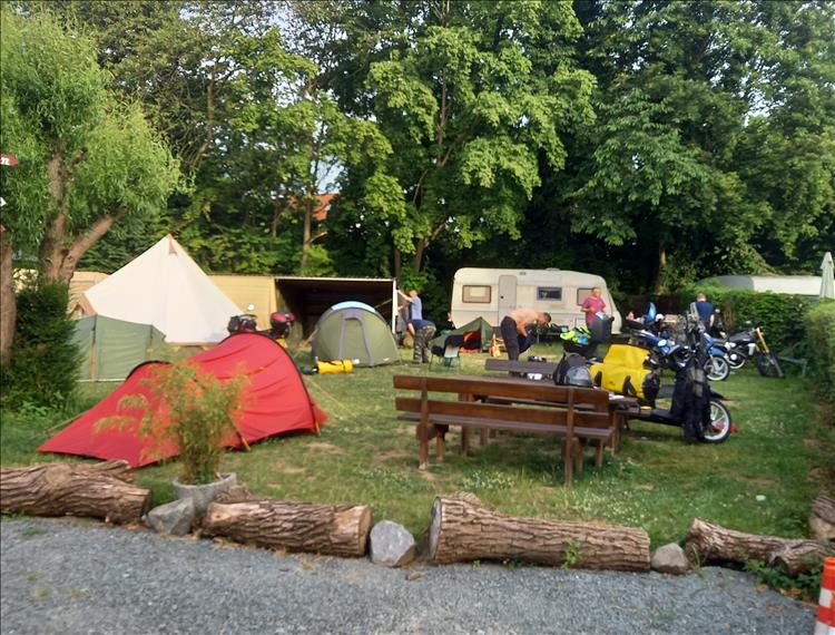 The chaps are up early a packing away by the trees and other camper's tents