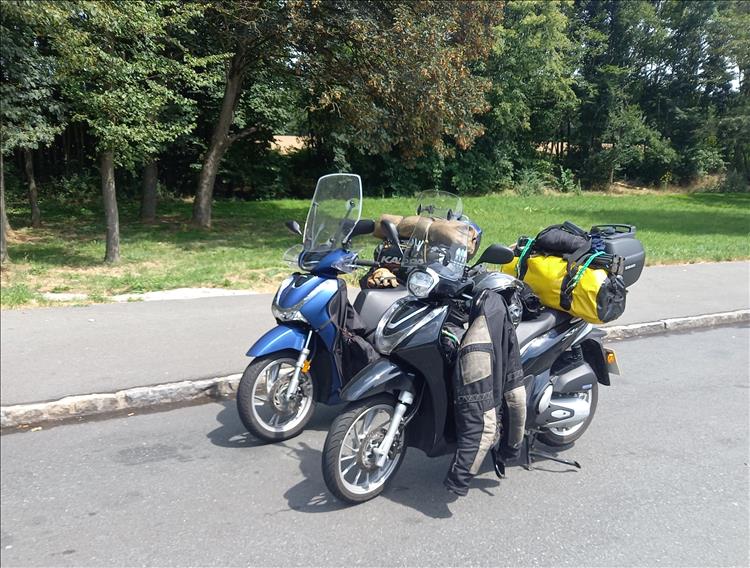 The same Honda scoots this time in a layby beside trees en route through Germany