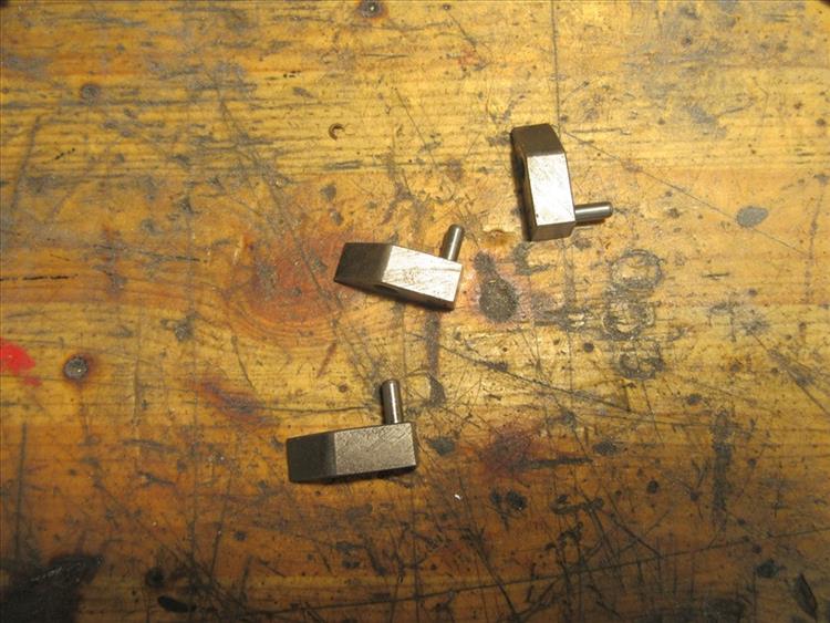 3 metal rhomboid shapes with pins, the pawls in the starter