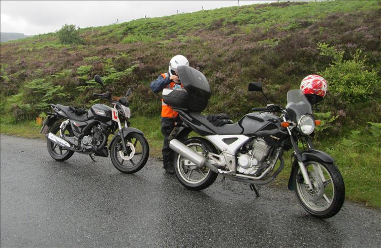 Sharon is rooting around in the top box of Ren's CBF250 in a remote Highland road