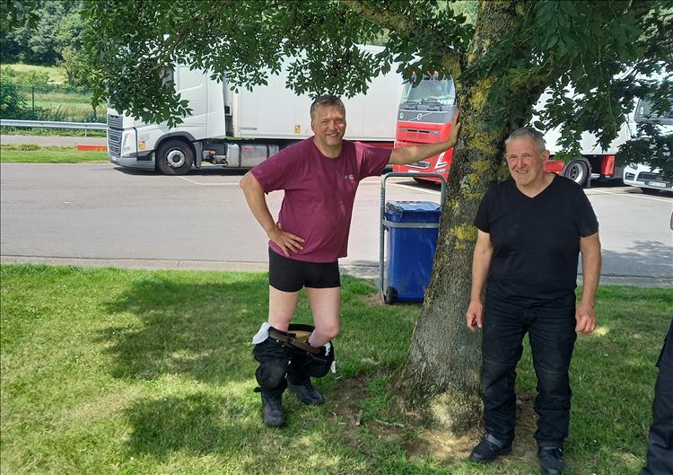 One chap has his pants around his ankles trying to cool off, stood under a tree in the baking sun