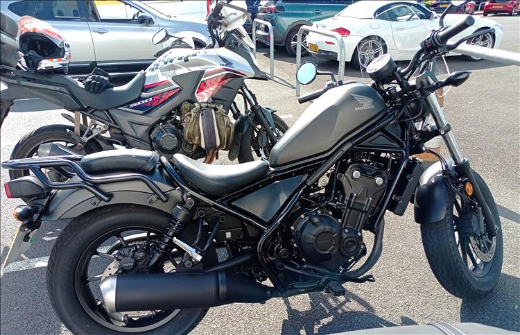 A dark grey and black Rebel 500 in front of Ren's dirty 500X
