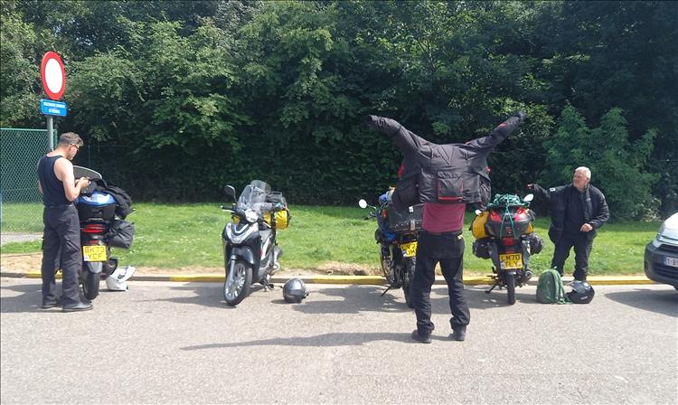 4 riders on 125cc motorcycles parked up and baking in the hot summer sun