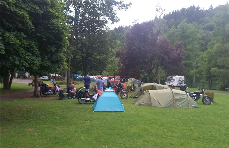 The tents and the small bikes of the lads among trees