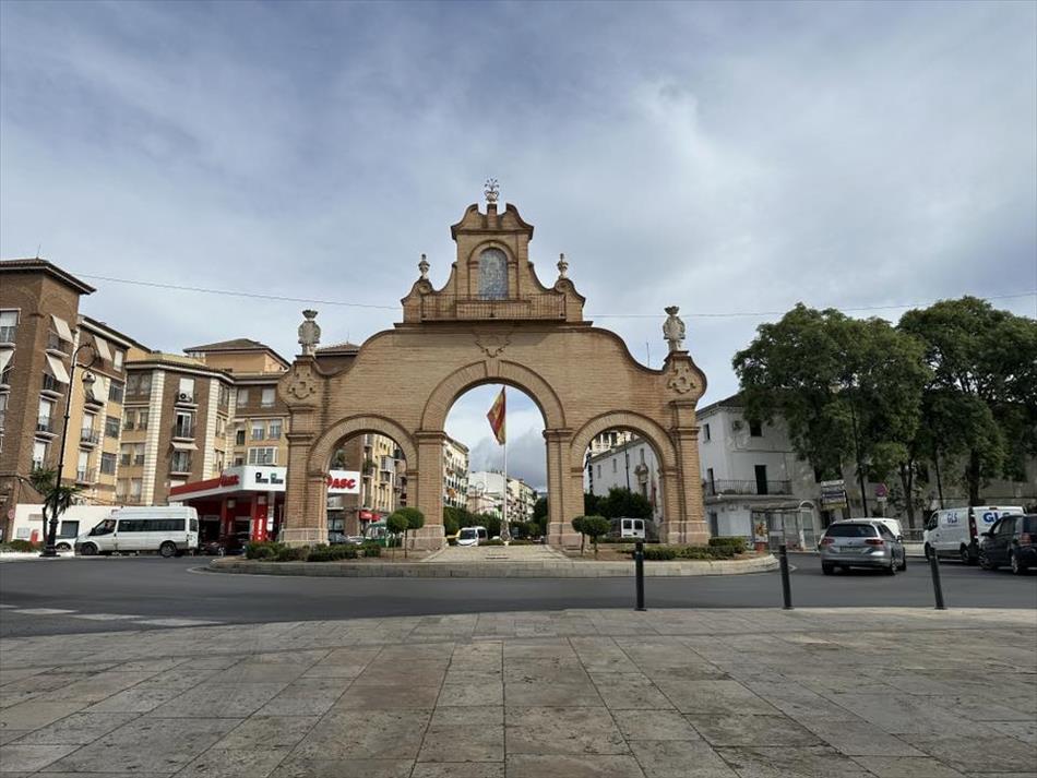 A spanish town centre and 3 arches across the street