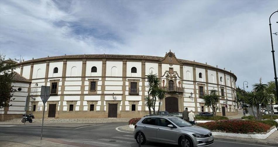 A large white curved building, the bullring in the town