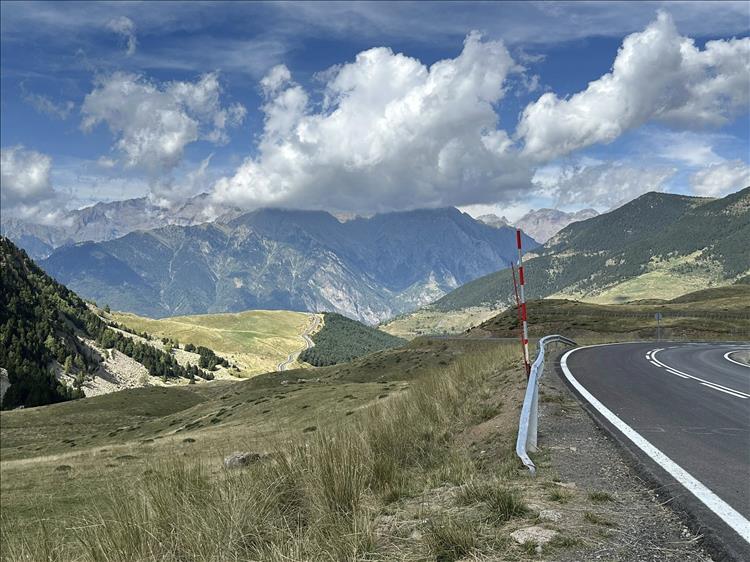 Pointy moutains, the winding road, snow poles, trees and scenery