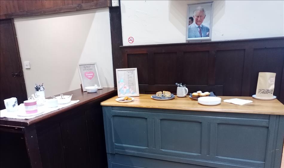 I picture of King Charles, a sideboard with cakes and biscuits, a counter with teacups