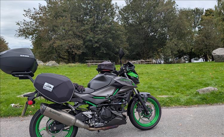 Sharon's Z500 in a layby with trees and benches, we can just make out the lake beyond the trees