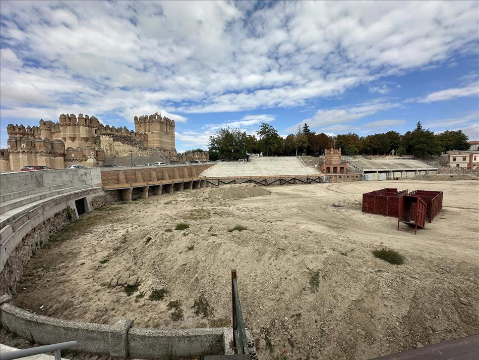 A bullring, looking "out of season" with scruff arena, the castle is behind