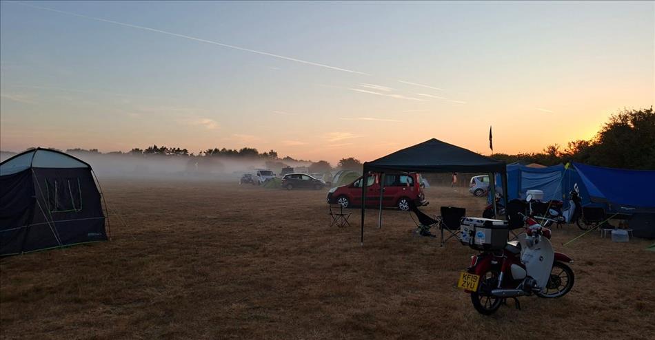 Clear skies as the sun rises and a hazy mist across the field between the tents and C90s