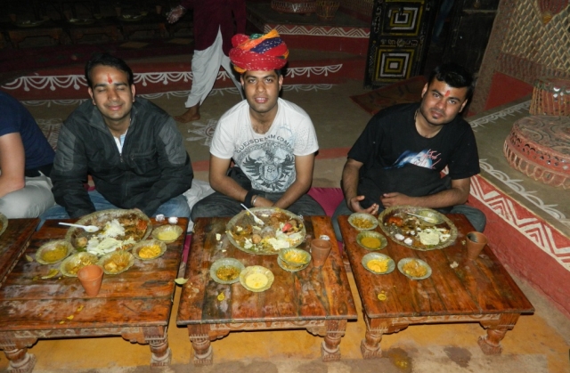 arjun and friends at on the floor eating a very hearty meal