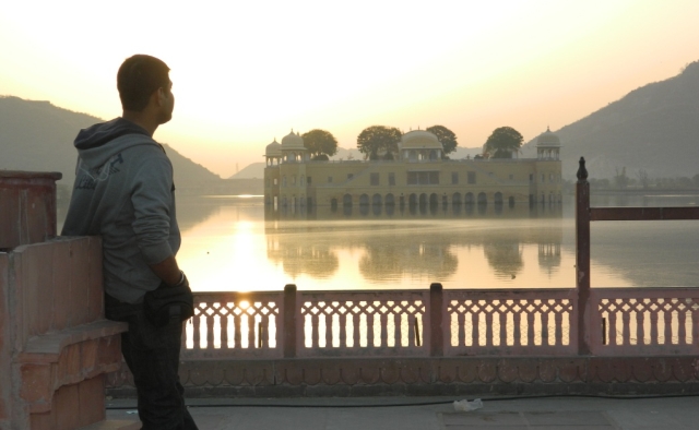 arjun looking over a flat lake to a palace in the indian sunshine