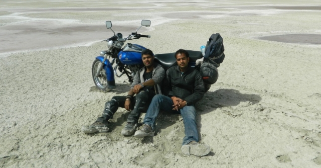 arjun and friend relaxing next to a bike on the salt lake