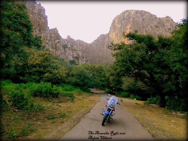 arjun's motorcycle set in the valley surrounded by very steep rock faces