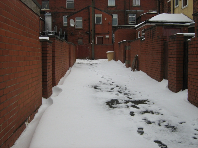 a narrow back alley covered in snow