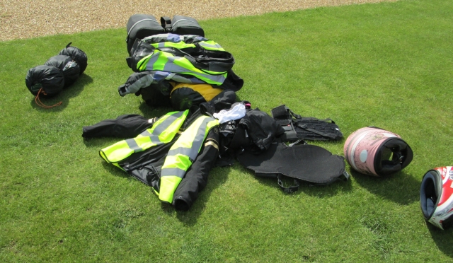 bike jackets, pants and luggage on the grass at the campsite in cambridge