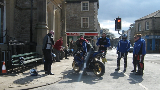 several motorcyclists in their leathers admiring a bike