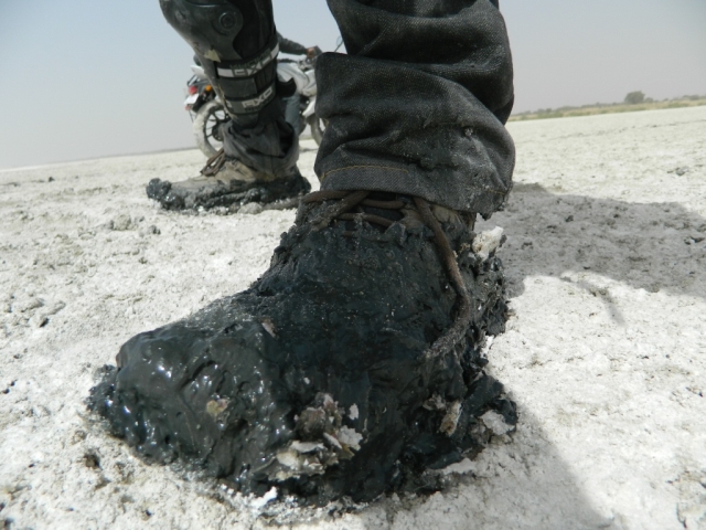 boots covered in black salty mud