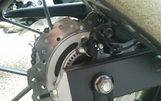 close up of the rear brake disc, brake caliper and abs sensor on the cb 500 x