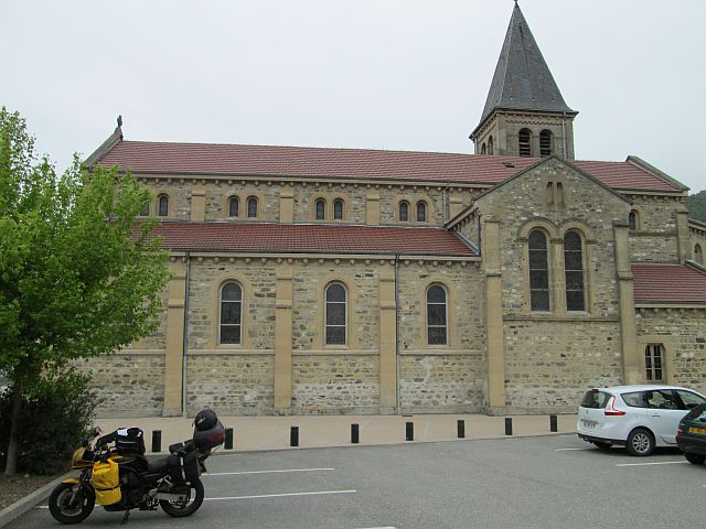 a clean and quite large church in chirens, france. notice the dry tarmac and the light skies