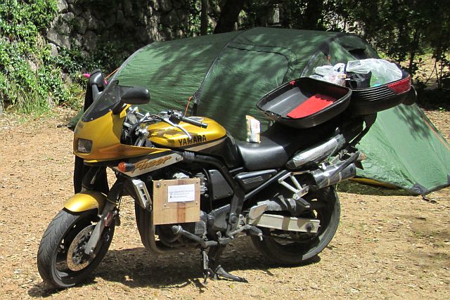 yamaha fzs 600 in the sunshine next to a tent at a campsite on the french riviera