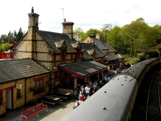 old fashioned train station with train taking on board passengers at haverthwaite