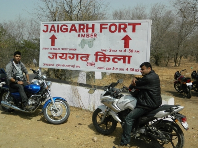 arjun and friend posing by the jaigarh fort sign