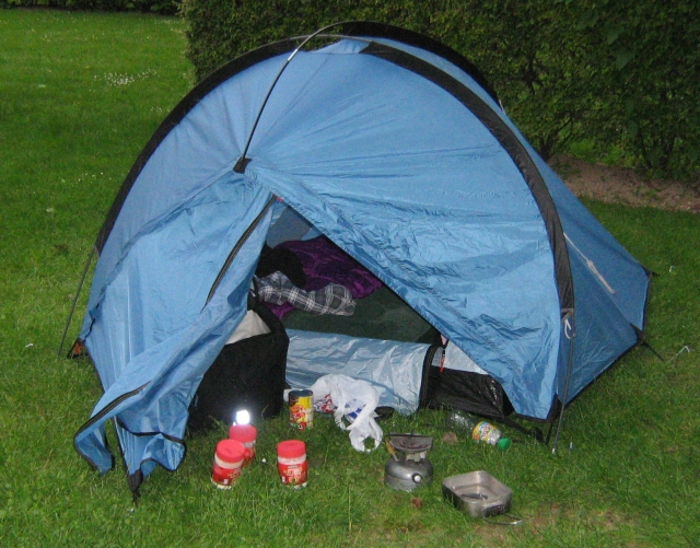 small tent with stove and pans out front