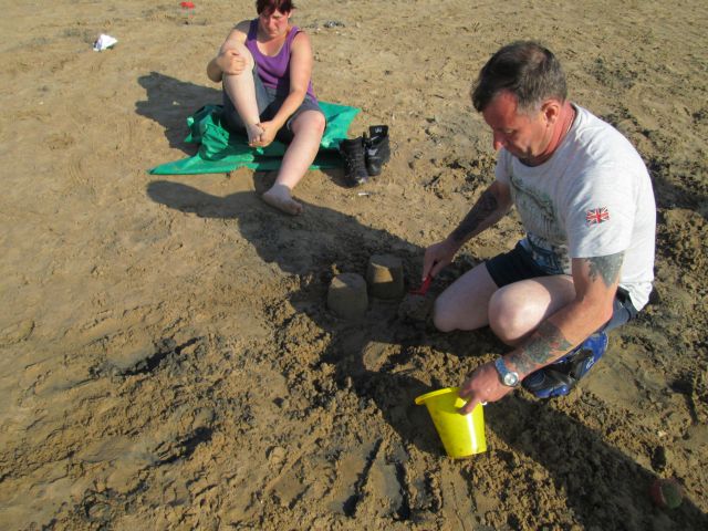 one biker makes sand castles while another turns pink