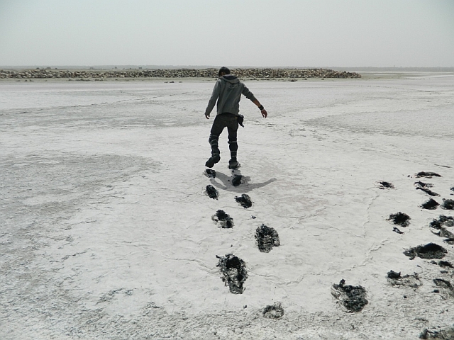man walking through the muddy sambhar salt lake
