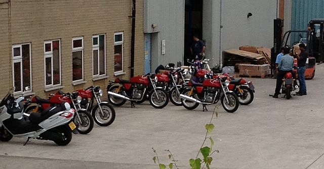 a row of brand new royal enfield cafe racers outside a workshop