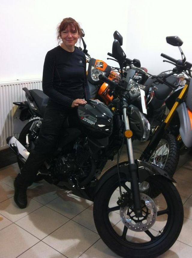 Sharon sat astride her brand new Keeway RKS 125 at the bike shop smiling