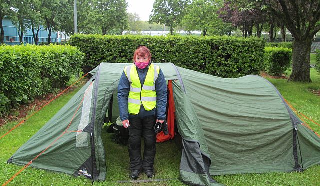 Sharon outside the wet tent in her waterproofs looking very wet