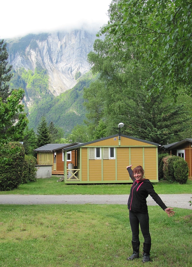 sharon in her thermal undies pointing to the steep mountins sides in le bourg d'oisans in the Alps